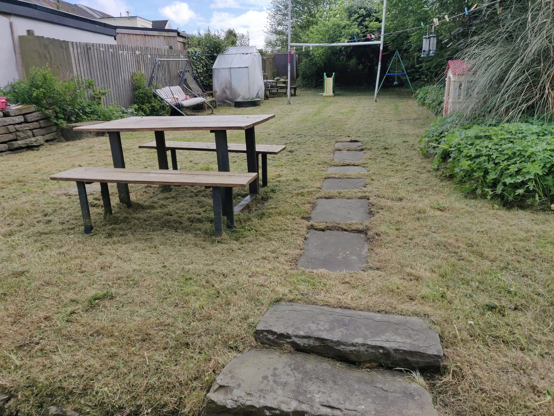 The same back garden after clearance, grass cut short and the stone path uncovered
